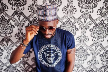 Zengin Afrika adam şık geleneksel giysiler ve şapka cam