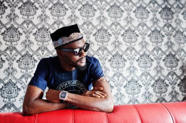 Zengin Afrika adam şık geleneksel giysiler ve şapka cam