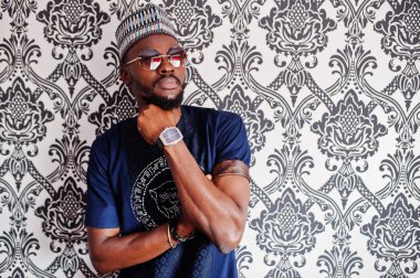 Zengin Afrika adam şık geleneksel giysiler ve şapka cam