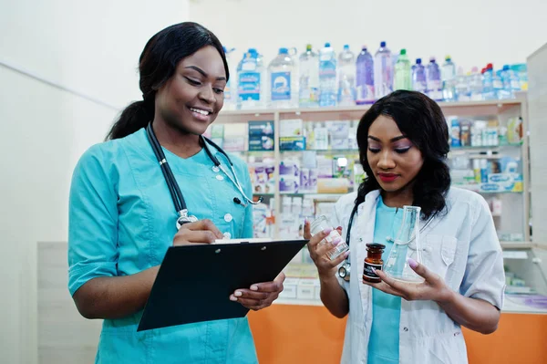 Dos farmacéuticos afroamericanos trabajando en farmacia en el hospital — Foto de Stock