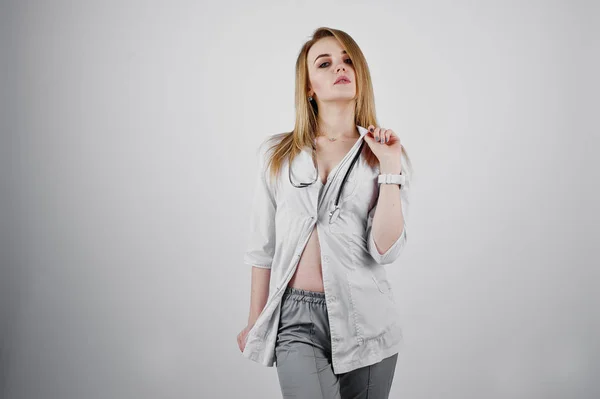 Blonde sexy médecin infirmière avec stéthoscope isolé sur le dos blanc — Photo
