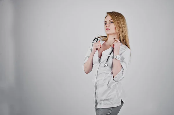 Sexy blondynka lekarz pielęgniarka z stetoskop na białym tle na biały tył Zdjęcia Stockowe bez tantiem