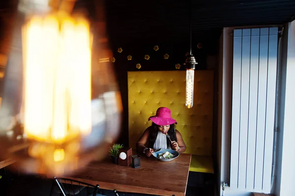카페에 앉아서 먹는 모자에 아프리카계 미국인 비즈니스 우먼 — 스톡 사진