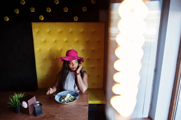 Africano americano mulher de negócios em chapéu sentado no café e comer — Fotografia de Stock