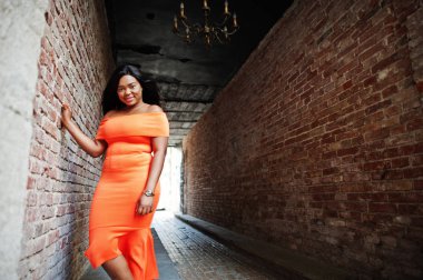 Afrikalı-Amerikalı kadın modeli xxl Turuncu elbiseli.