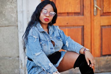 Afro-Amerikan kız kot elbise ve güneş gözlüğü str poz verdi.