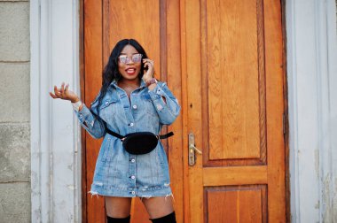 Afro-Amerikan kız kot elbise ve konuşan güneş gözlüğü 