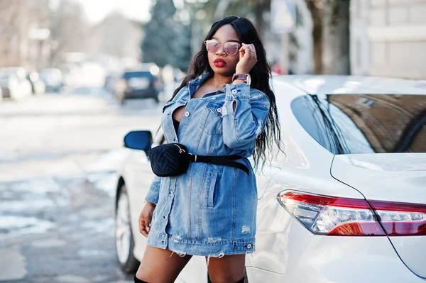 African american girl in jeans dress and sunglasses posed agains