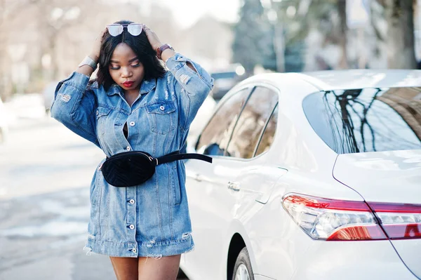 African american girl in jeans dress and sunglasses posed agains