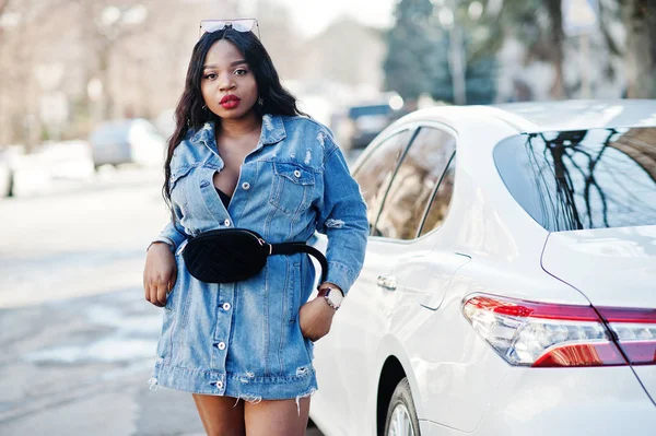 African american girl in jeans dress and sunglasses posed agains