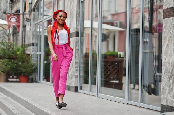 Fashionabla afroamerikanska flicka på Rosa byxor och röda dreads p — Stockfoto