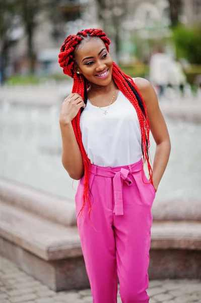 Chica afroamericana de moda en pantalones rosas y rastas rojas p — Foto de Stock