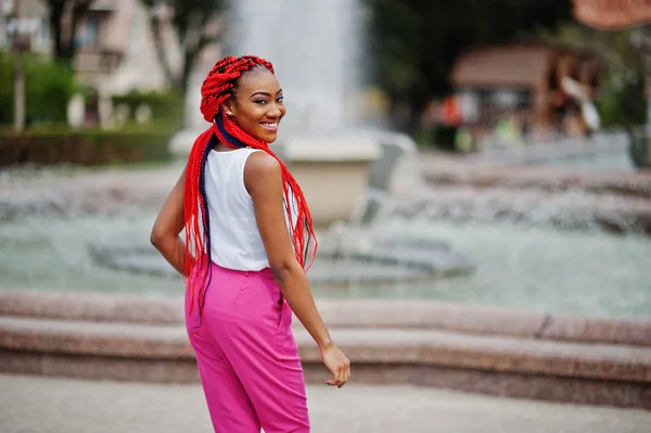 Chica afroamericana de moda en pantalones rosas y rastas rojas p — Foto de Stock