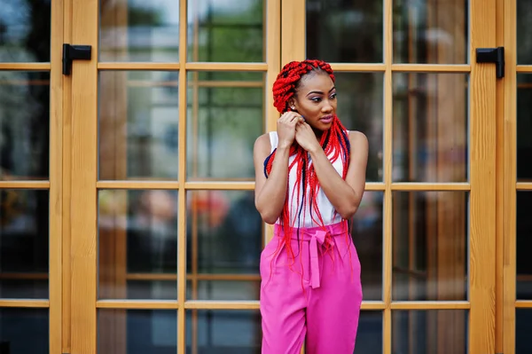 Модная африканская девушка в розовых штанах и красных страшилках. — стоковое фото