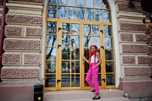 Modische afrikanisch-amerikanische Mädchen in rosa Hosen und roten Dreadlocks p — Stockfoto