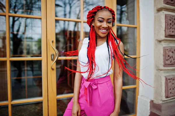 Chica afroamericana de moda en pantalones rosas y rastas rojas p — Foto de Stock