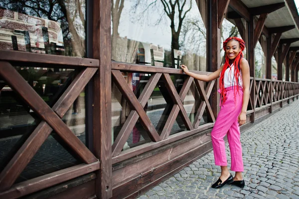 Chica afroamericana de moda en pantalones rosas y rastas rojas p — Foto de Stock
