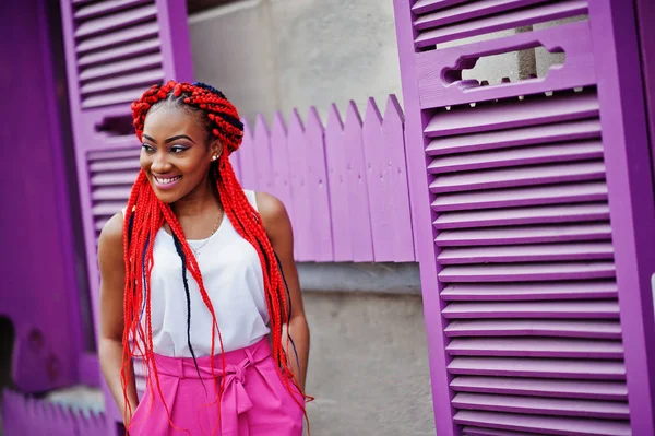 Chica afroamericana de moda en pantalones rosas y rastas rojas p — Foto de Stock