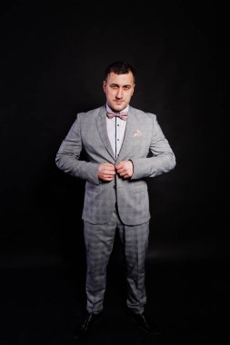 Gri takım elbise ve kravat siyah ba karşı adam portresi stüdyo