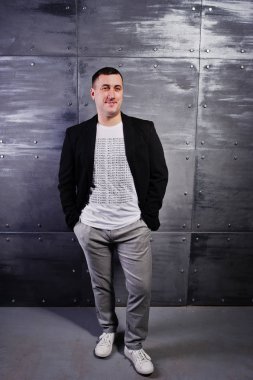 Çelik arka plan karşı rahat kıyafetli adam portresi stüdyo.