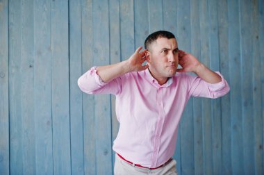 Ahşap arka plan karşı pembe tişörtlü adam portresi stüdyo.