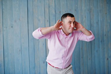 Ahşap arka plan karşı pembe tişörtlü adam portresi stüdyo.