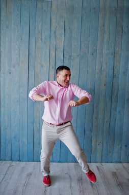 Ahşap arka plan karşı pembe tişörtlü adam portresi stüdyo.