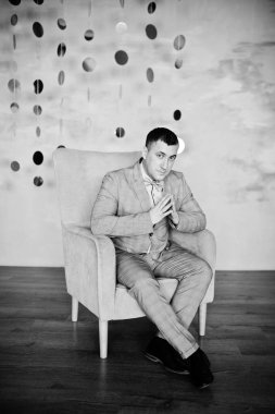 Stüdyo portre sandalye yakınındaki takım elbiseli adam.