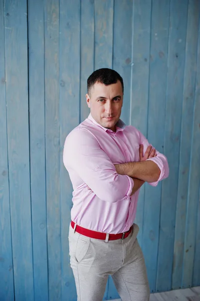 Студийный портрет человека в розовой рубашке на деревянном фоне . — стоковое фото