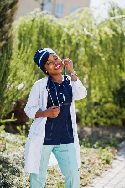 Médico afroamericano femenino con estetoscopio posado al aire libre . —  Fotos de Stock