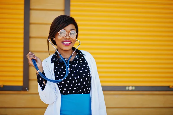 Africano americano médico mujer con estetoscopio posado al aire libre ba —  Fotos de Stock