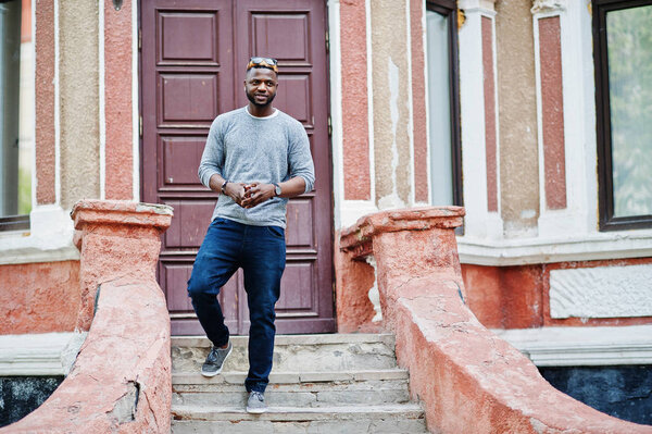 Стильный африканский американец в сером свитере и черном солнцезащитном стекле
