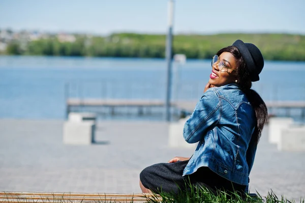 Eleganta afroamerikanska modell i glasögonen hatt, jeansjacka och — Stockfoto