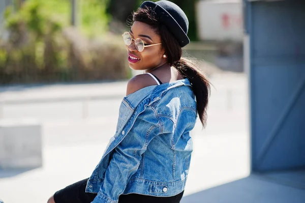 Stijlvolle Afro-Amerikaanse model in glazen hoed, jeans jasje en — Stockfoto