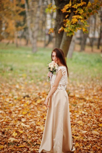 Amazingly girl bridesmaid in golden dress with bouquet at hands — Stock Photo, Image