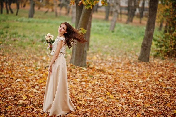Amazingly girl bridesmaid in golden dress with bouquet at hands — Stock Photo, Image