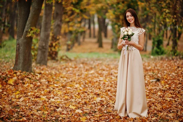 Удивительно девушка-подружка невесты в золотом платье с букетом на руках — стоковое фото