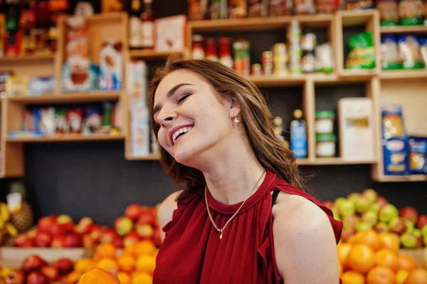 Girl in red holding different vegetables on fruits store. — Stock Photo, Image