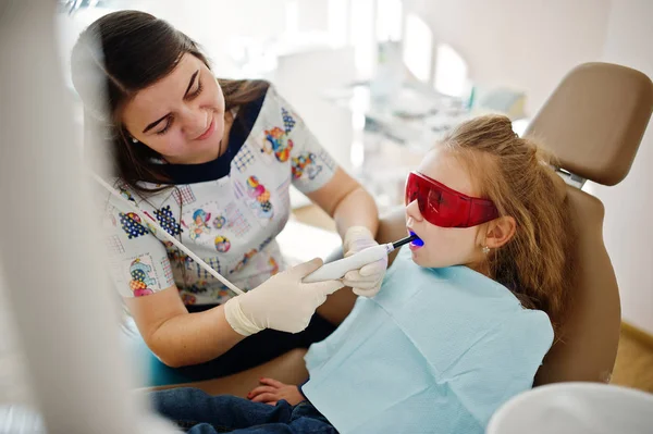 Kleines Mädchen auf dem Zahnarztstuhl. Kinderzahnheilkunde. — Stockfoto