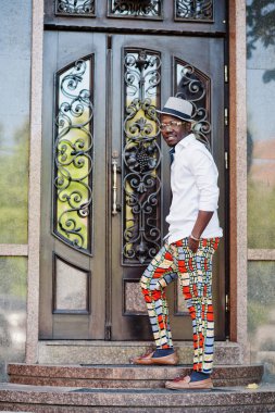 Kablosuz beyaz gömlek ve renkli şık Afro-Amerikan erkek pantolon