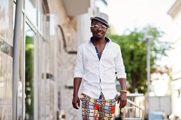 Стильный африканский американец в белой рубашке и цветных брюках с — стоковое фото