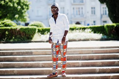 Kablosuz beyaz gömlek ve renkli şık Afro-Amerikan erkek pantolon