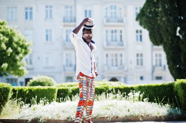 Kablosuz beyaz gömlek ve renkli şık Afro-Amerikan erkek pantolon