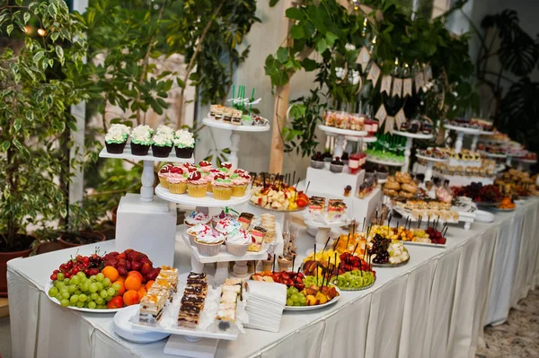 Mesa de postres de deliciosos dulces en la recepción de la boda. — Foto de Stock