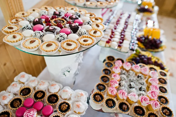 Mesa de postres de deliciosos dulces en la recepción de la boda. — Foto de Stock