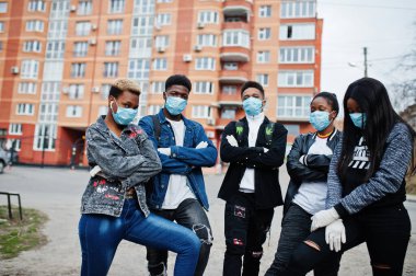 Bir grup Afrikalı genç, tıbbi maskeli ve boş sokaklara karşı Coronavirus virüsü virüsü taşıyan enfeksiyon ve hastalıklara karşı korunan arkadaşlar..