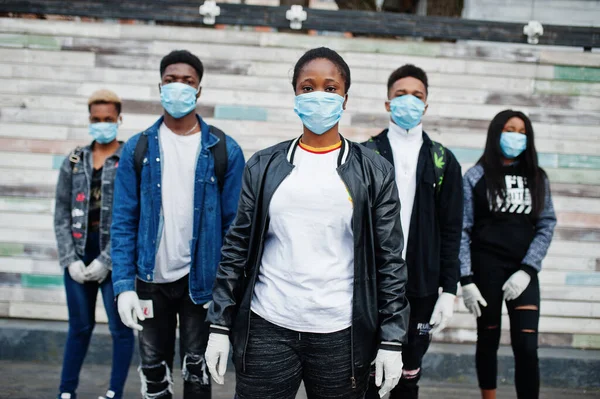 Group of african teenagers friends wearing medical masks protect from infections and diseases coronavirus virus quarantine.