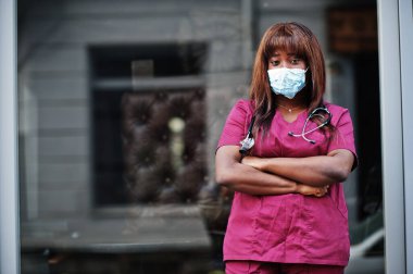 Kırmızı laboratuvar üniformalı koruyucu maskeli Afrikalı Amerikalı kadın doktor. Tıp, meslek ve sağlık hizmetleri kavramı. Coronavirüs enfeksiyonunu durdur.