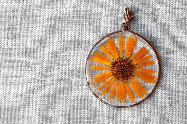 handmade epoxy resin jewelry. pendant. calendula officinalis flower in copper frame