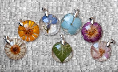 handmade epoxy resin jewelry. pendants. in copper frame. chamomile, calendula, lobelia, hydrangea, rose, delphinium, ivy clipart